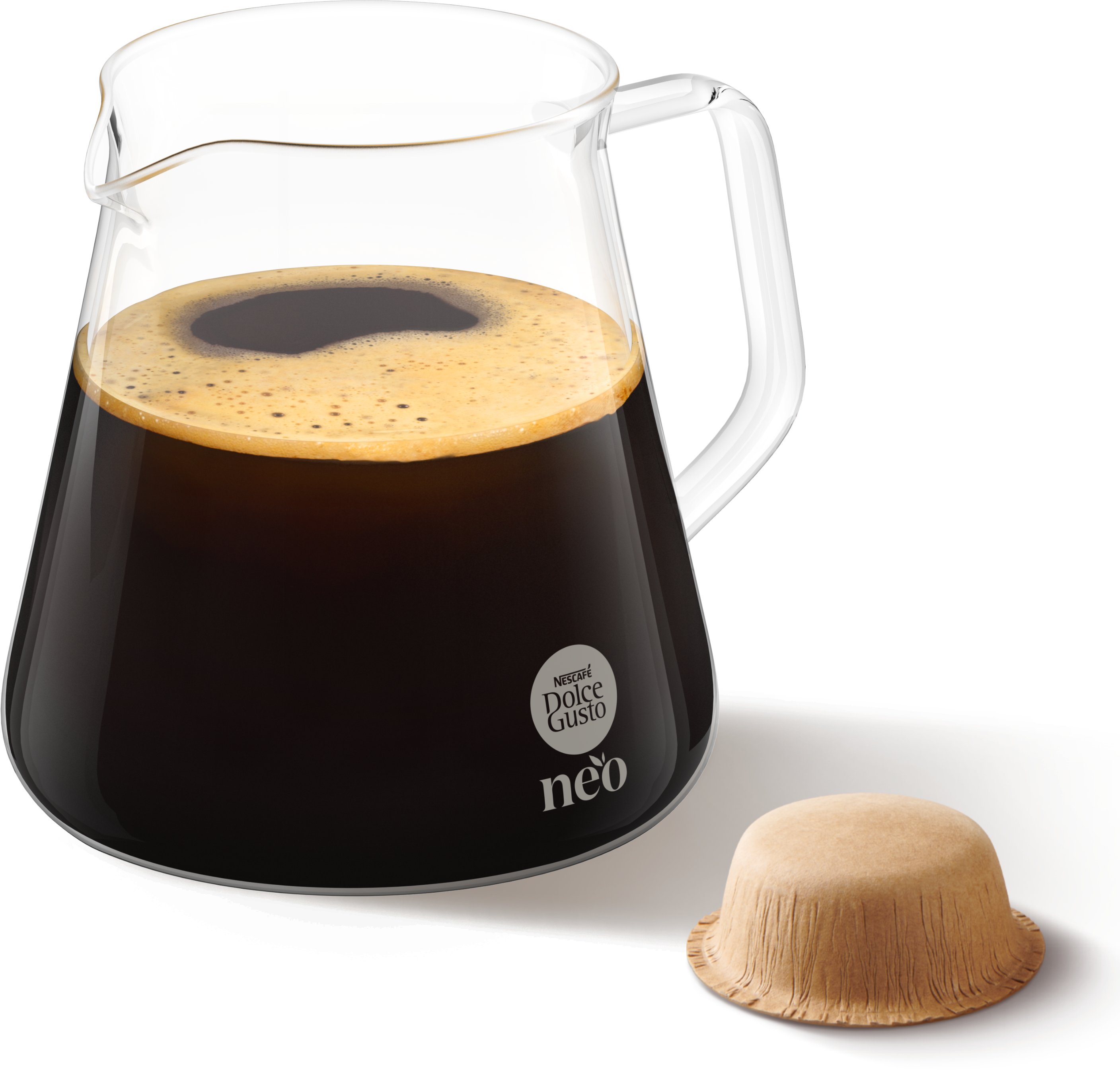 Glas Kanne gefüllt mit frischem Kaffee und Schaum, daneben ein Kaffeepad vor weißem Hintergrund.