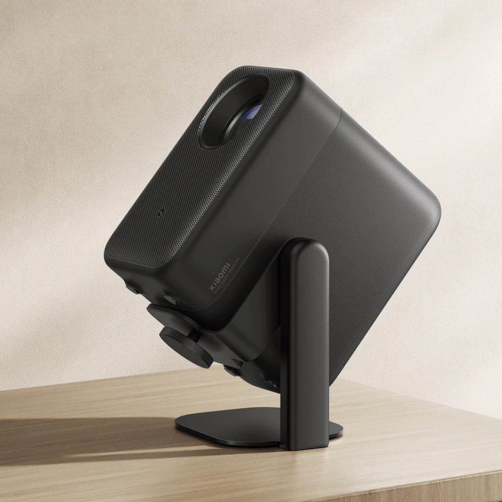 Un proiettore home theater Xiaomi nero su un tavolo, montato su un supporto in metallo.
