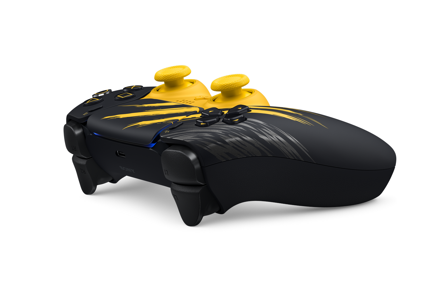 Un mando de PlayStation negro y amarillo con joysticks amarillos y diseños sobre un fondo negro.