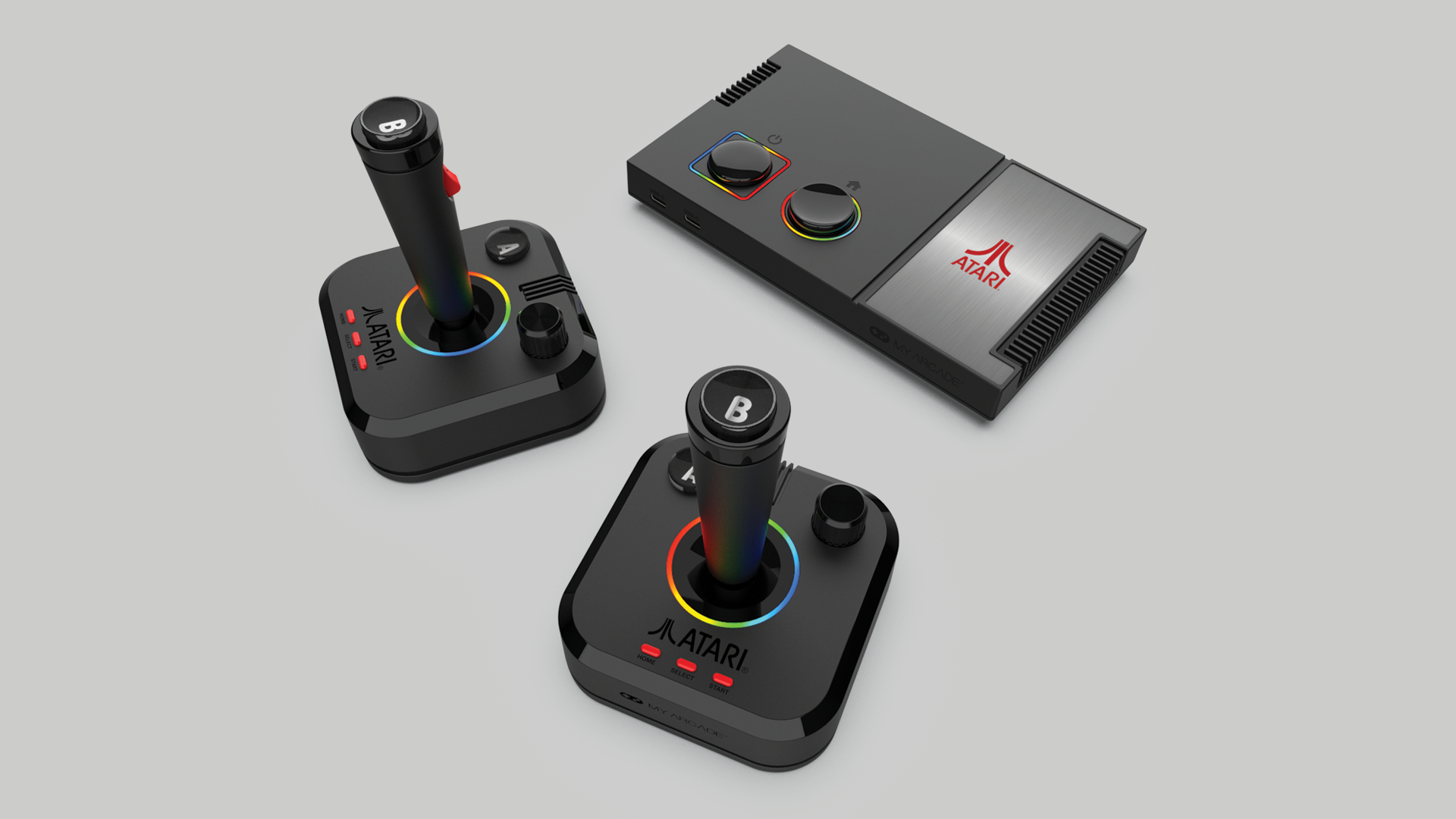 Eine schwarze Atari-Retrokonsole mit zwei Joysticks, farbigen Ringen und Tasten auf grauem Hintergrund.