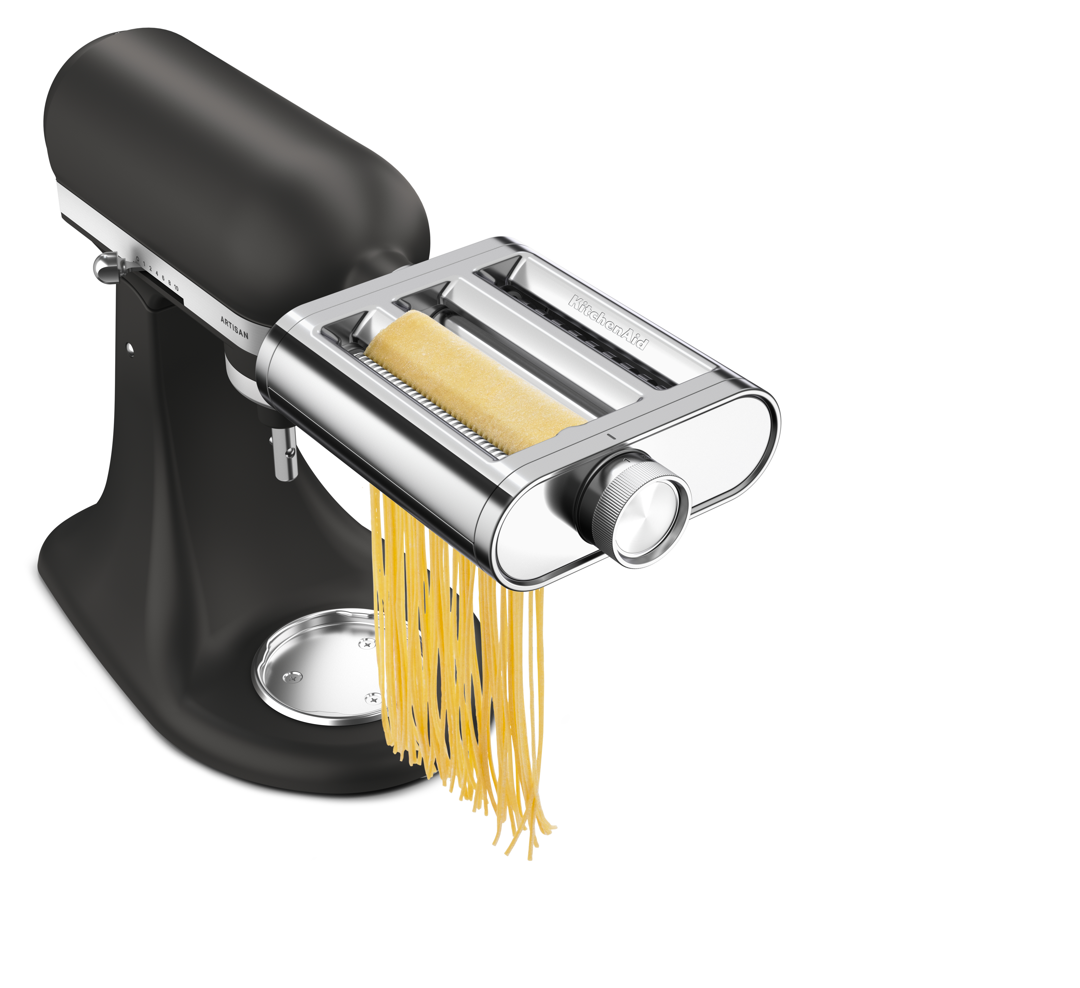 Eine schwarze KitchenAid Küchenmaschine mit silbernem Nudelwalzen-Aufsatz schneidet frische Spaghetti vor weißem Hintergrund.