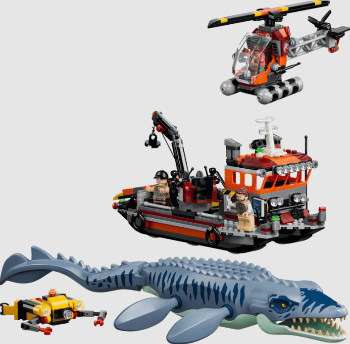 Lego Set mit einem großen blauen Mosasaurus, einem Rettungsboot, einem Hubschrauber und Minifiguren.