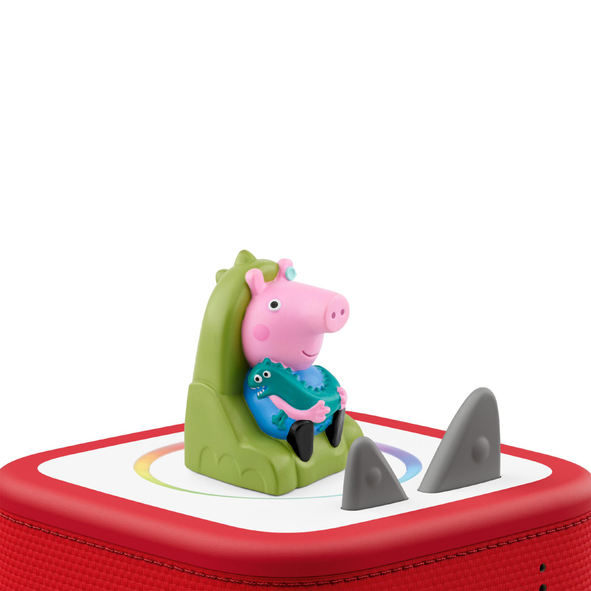 Eine rosa Peppa Wutz Figur sitzt auf einem grünen Stuhl auf einer roten Box.