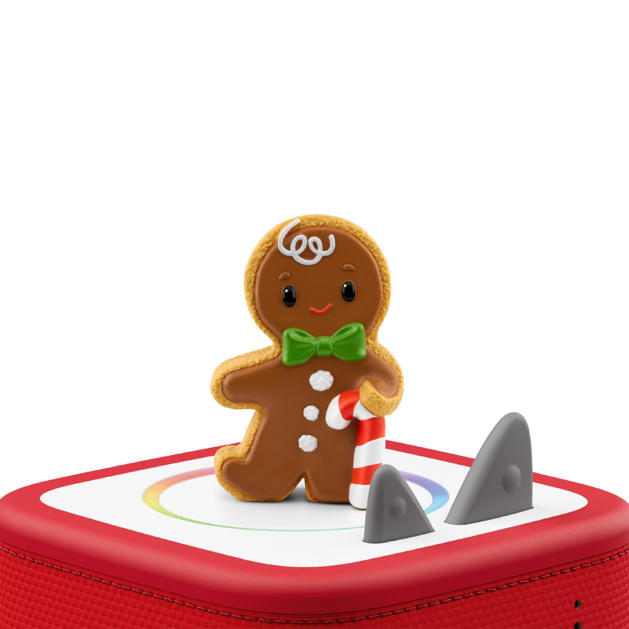 Eine Lebkuchenmann-Figur mit Fliege und Zuckerstange steht auf einer rot-weißen Box mit kleinen Hai-Flossen.
