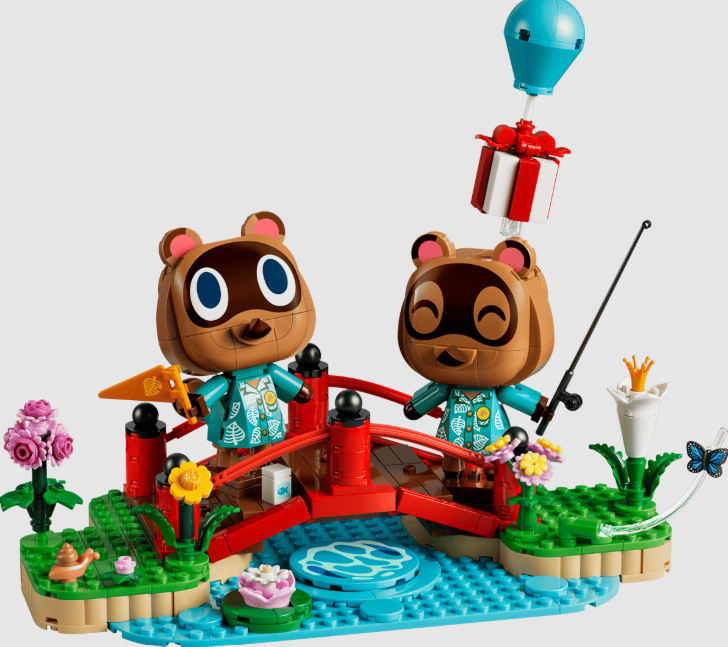 Lego Animal Crossing Set mit zwei Waschbären auf roter Brücke über blauem Wasser mit Blumen und Geschenk.
