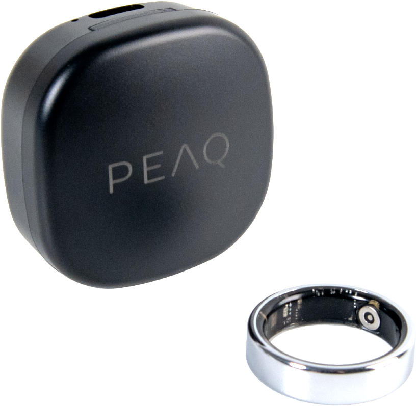 Un boîtier de charge noir marqué PEAQ et une bague connectée argentée sur fond noir.