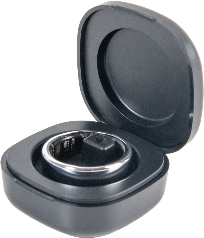 Une bague connectée argentée repose dans son étui de charge noir ouvert sur fond sombre.