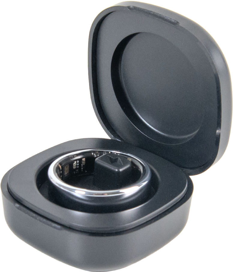 Une bague connectée argentée repose dans son étui de charge noir ouvert sur fond noir.