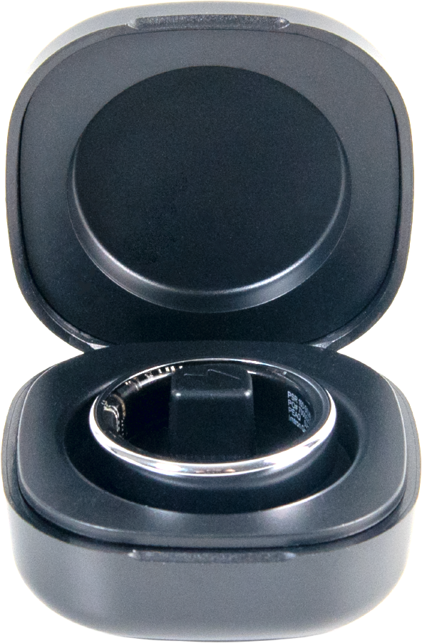 Une bague argentée dans un boîtier de charge noir ouvert avec support central.
