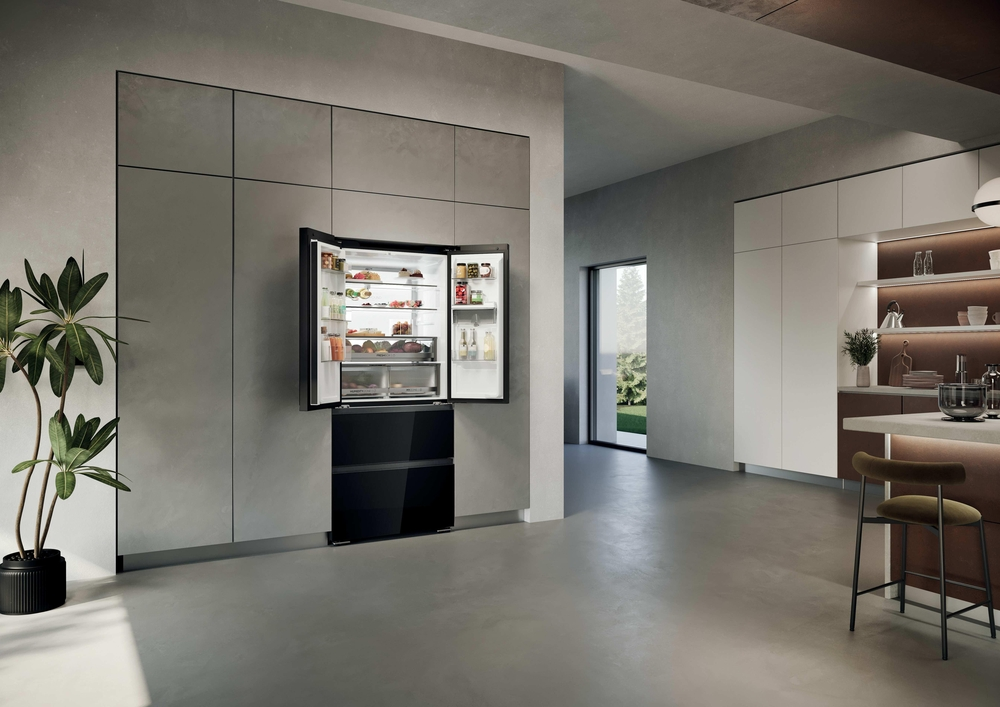 Moderner offener Kühlschrank in eleganter Küche mit Betonwand und Topfpflanze.