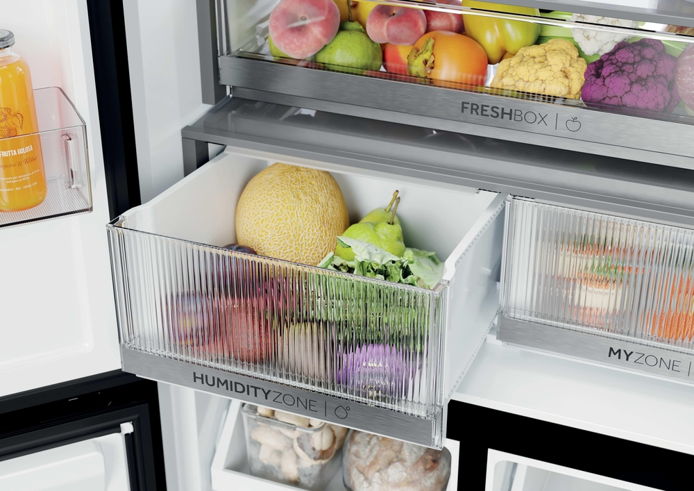 Geöffnete Kühlschrank-Schublade mit frischem Obst und Gemüse wie Melone und Birnen.