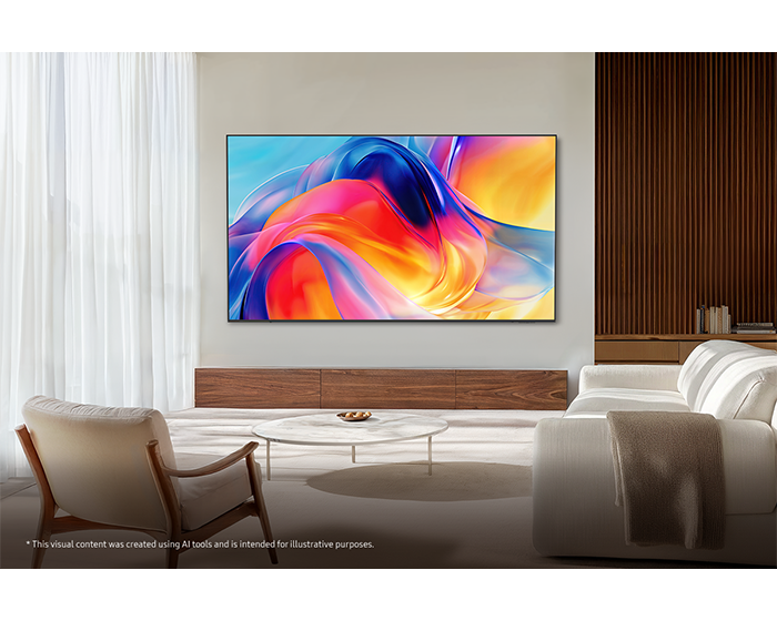 Modernes Wohnzimmer mit großem Fernseher an der Wand, hellem Sofa, Sessel und Couchtisch.
