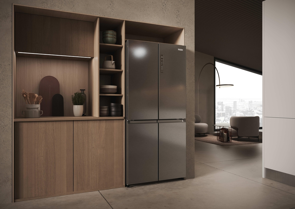 Moderner grauer Haier-Viertürer-Kühlschrank eingebaut in Holzschränke in einer minimalistischen Küche.