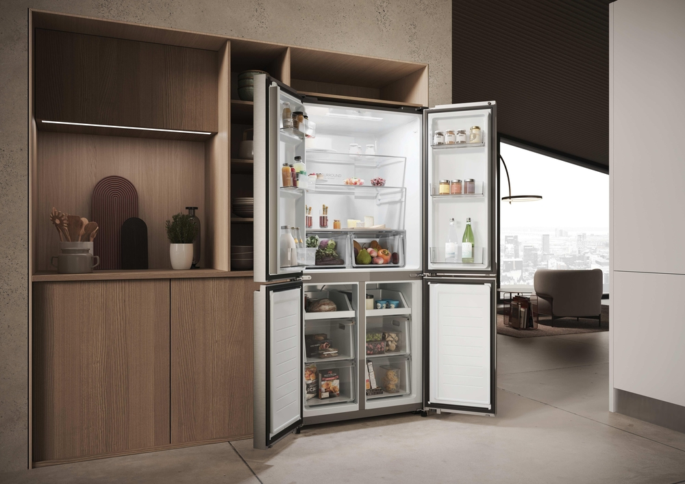 Offener silberner Kühlschrank mit Lebensmitteln in einer modernen Holzküche.