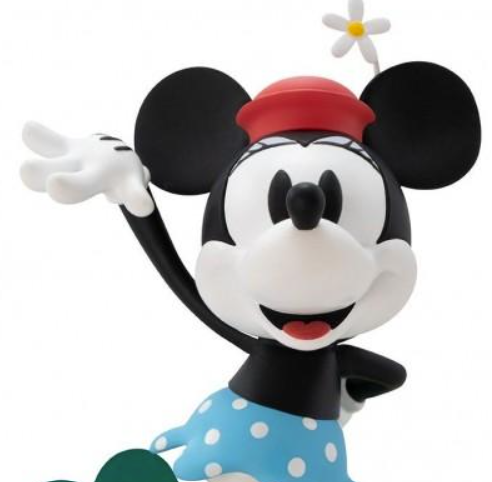 Minnie Maus Figur mit rotem Hut, blauer gepunkteter Rock und winkender Hand.