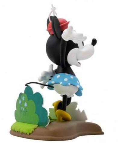 Eine Minnie-Maus-Figur mit blauem Punktrock und rotem Hut auf einem Diorama.
