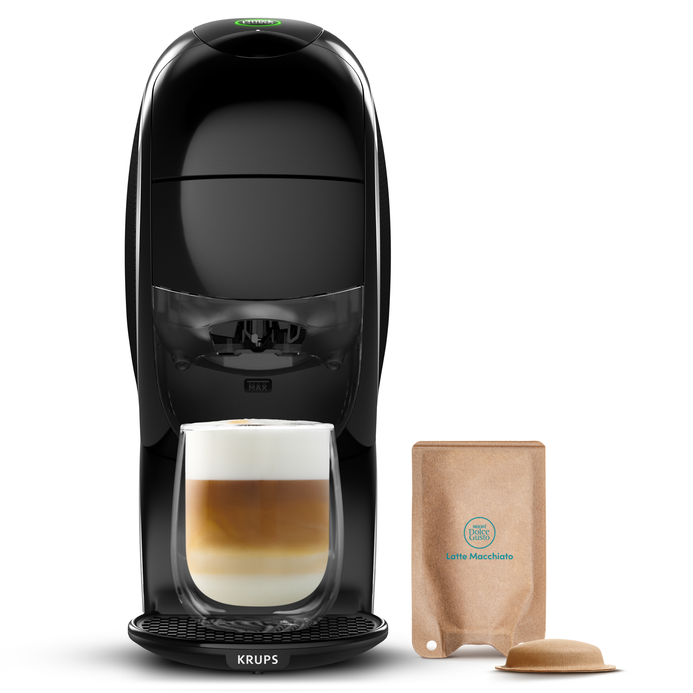 Cafetera Krups negra con una taza de cristal de latte macchiato y cápsulas de café sobre fondo blanco.