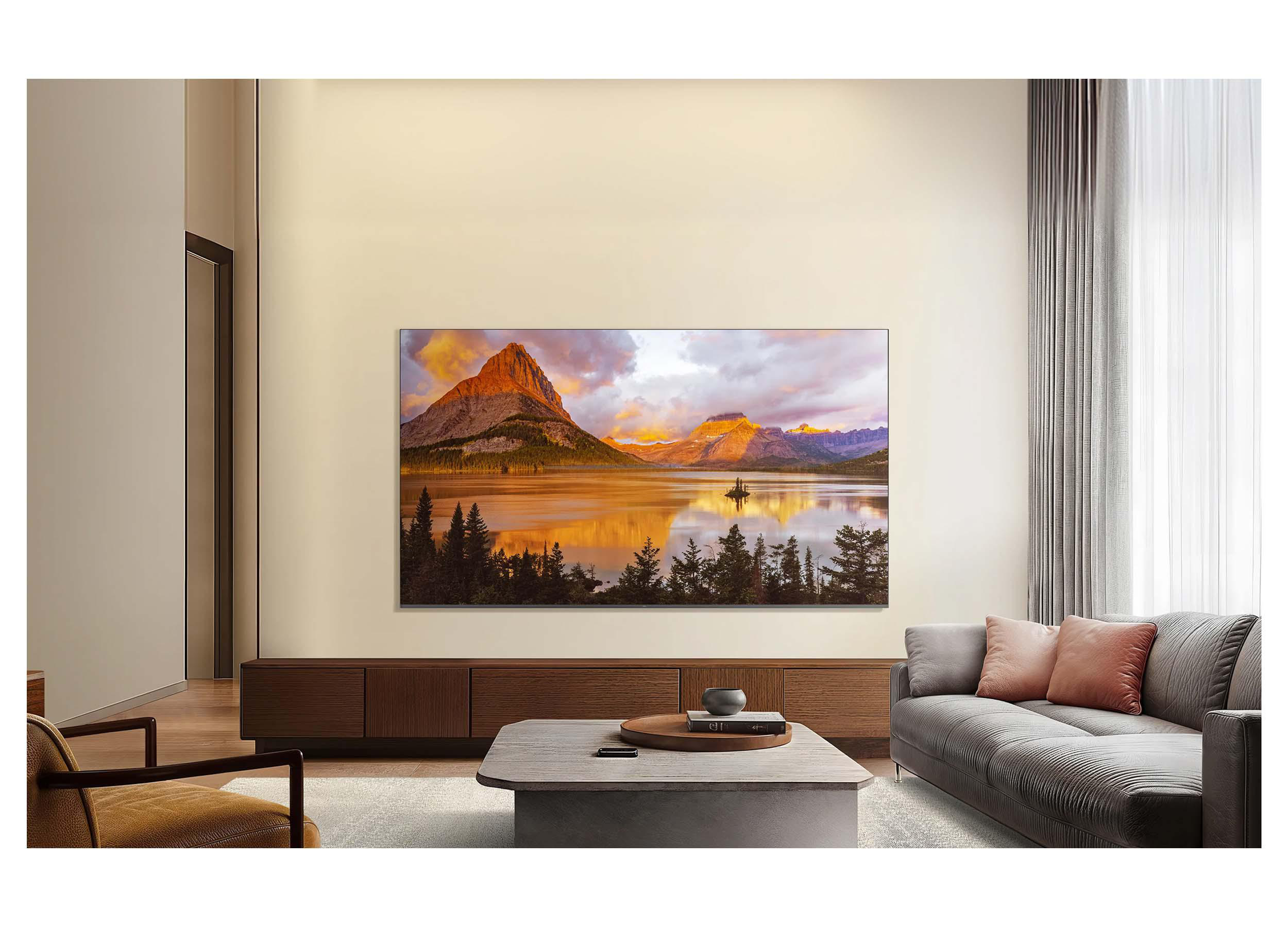 Ein modernes Wohnzimmer mit einem großen Wandfernsehgerät, das eine Berglandschaft zeigt.