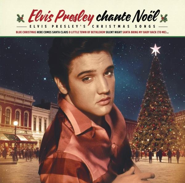 Elvis Presley vor einem großen, beleuchteten Weihnachtsbaum in einer verschneiten Stadt.