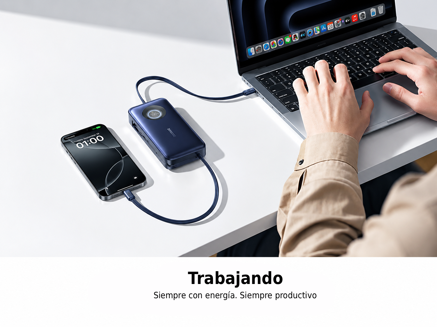 Una persona escribe en un portátil conectado por un cable azul a una batería externa que carga un smartphone.