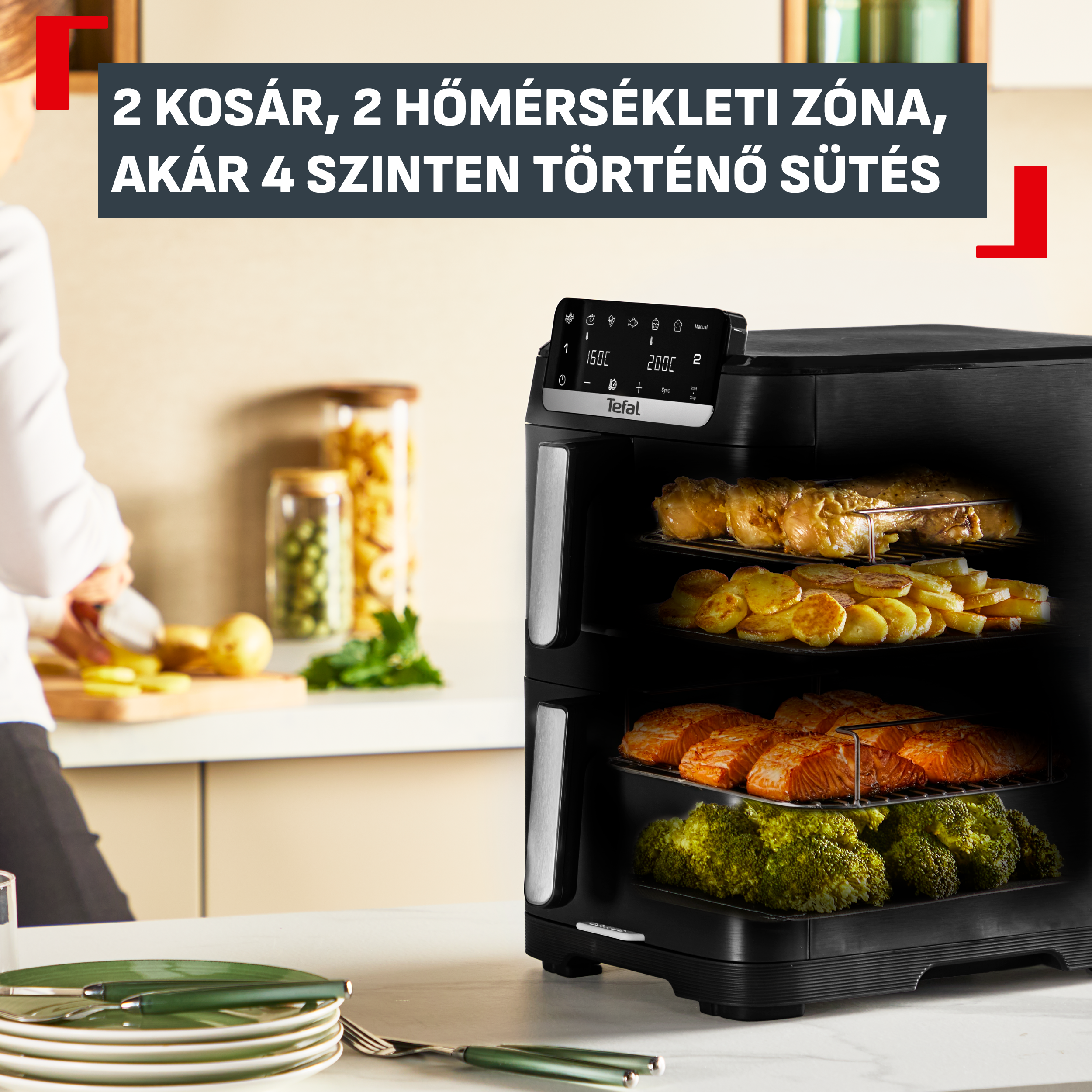 Fekete, többszintes forrólevegős sütő csirkével, burgonyával, lazaccal és brokkolival.