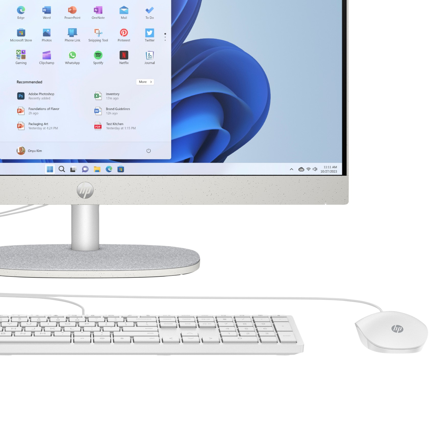 Un ordenador todo en uno HP que muestra el menú de inicio, con un teclado y ratón blancos.