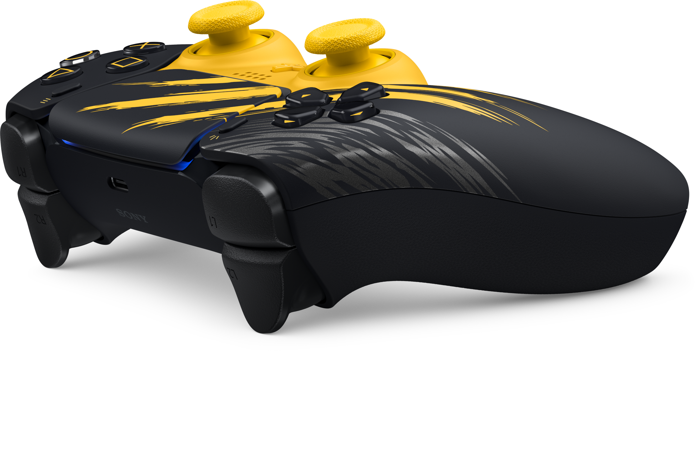 Fekete-sárga PlayStation kontroller sárga analóg karokkal és karc mintákkal fekete háttér előtt.