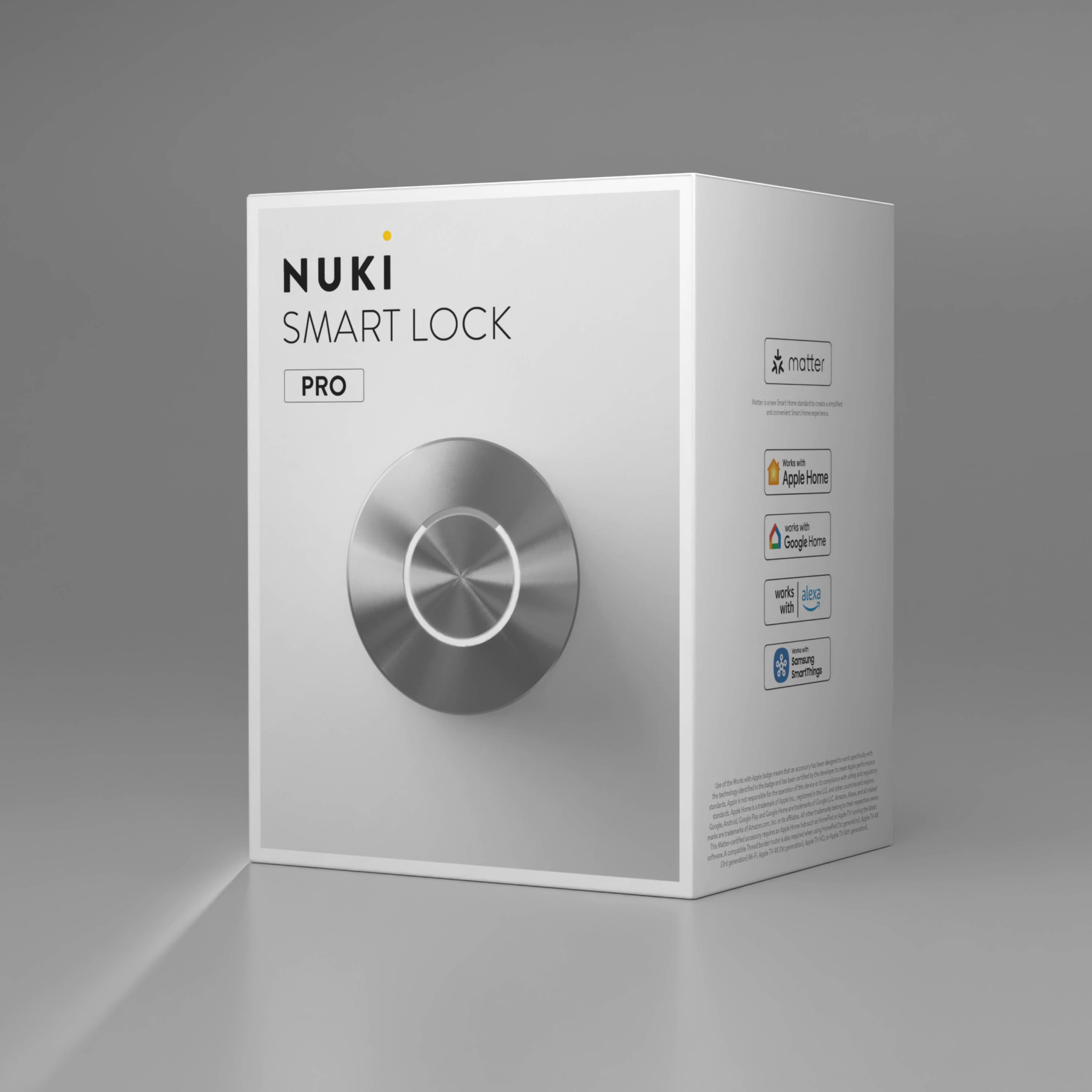 Weiße Produktverpackung des Nuki Smart Lock Pro mit rundem Metallknauf auf einer grauen Oberfläche.