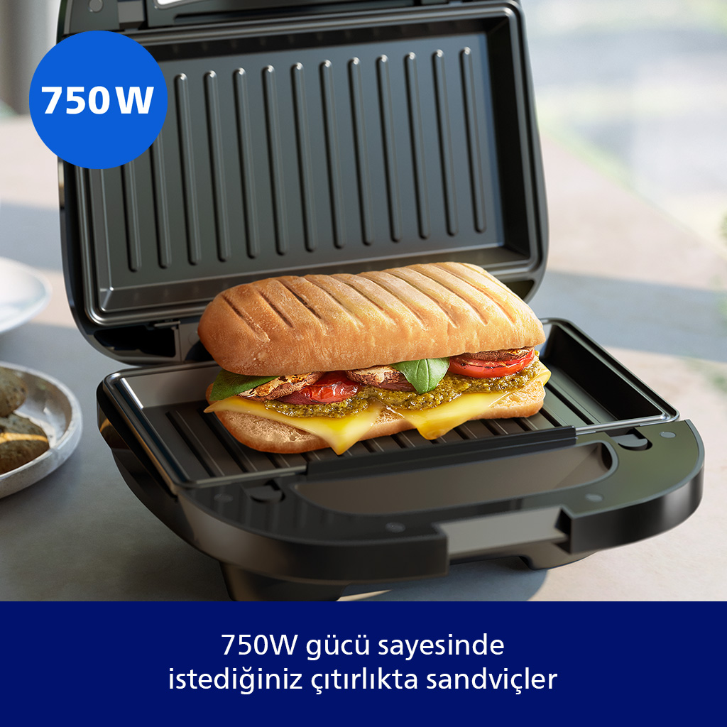 Siyah 750W'lık bir tost makinesinde ısıtılan dolgulu bir panini ve köşesinde mavi bir rozet.