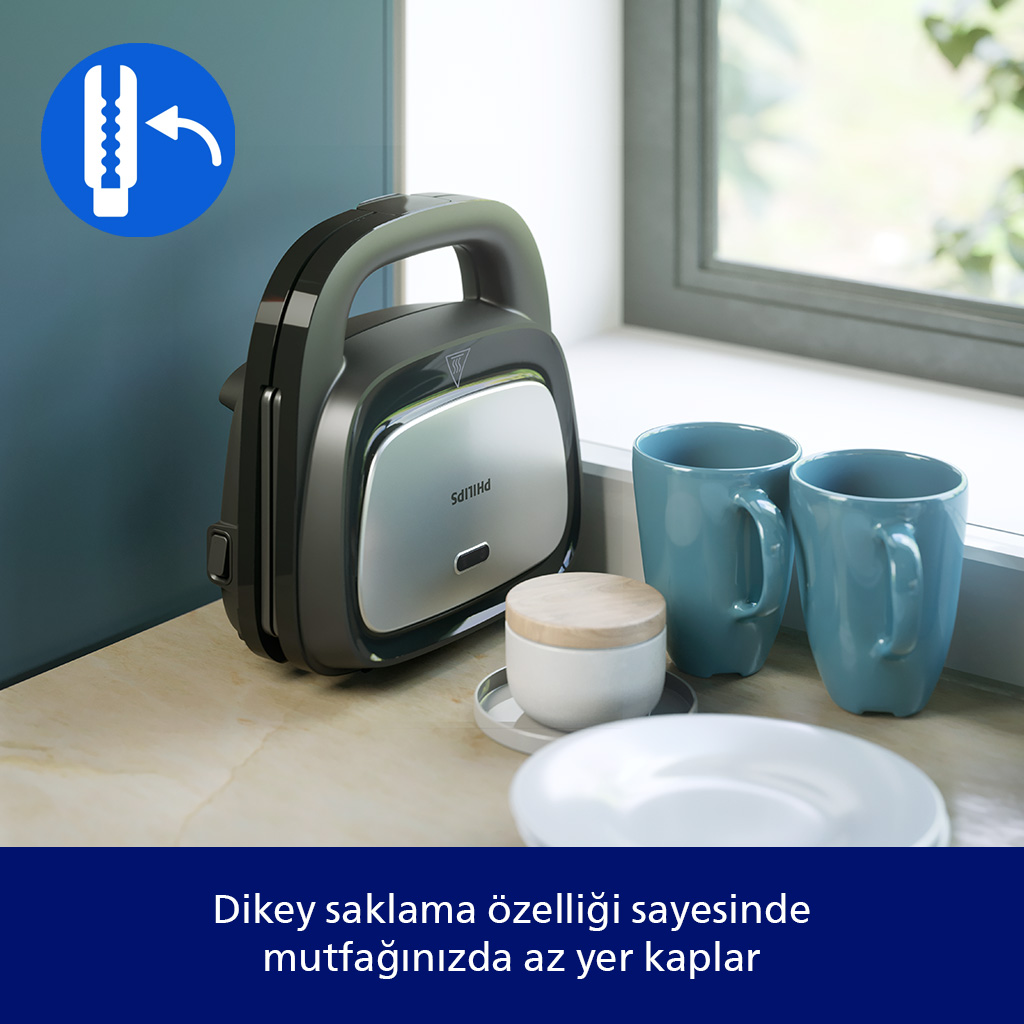 Siyah bir Philips tost makinesi mutfak tezgahında mavi kupaların yanında duruyor.