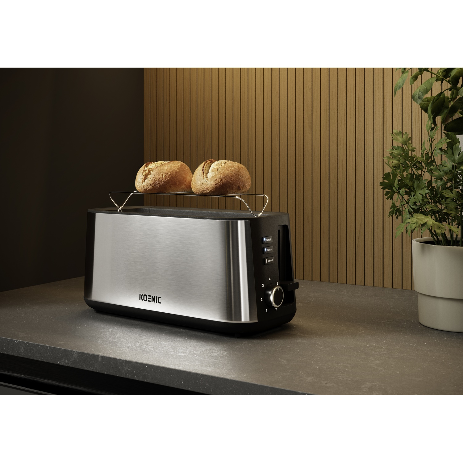 Roestvrijstalen lange sleuf broodrooster met broodjeswarmer op een grijs aanrecht, met een plant ernaast.
