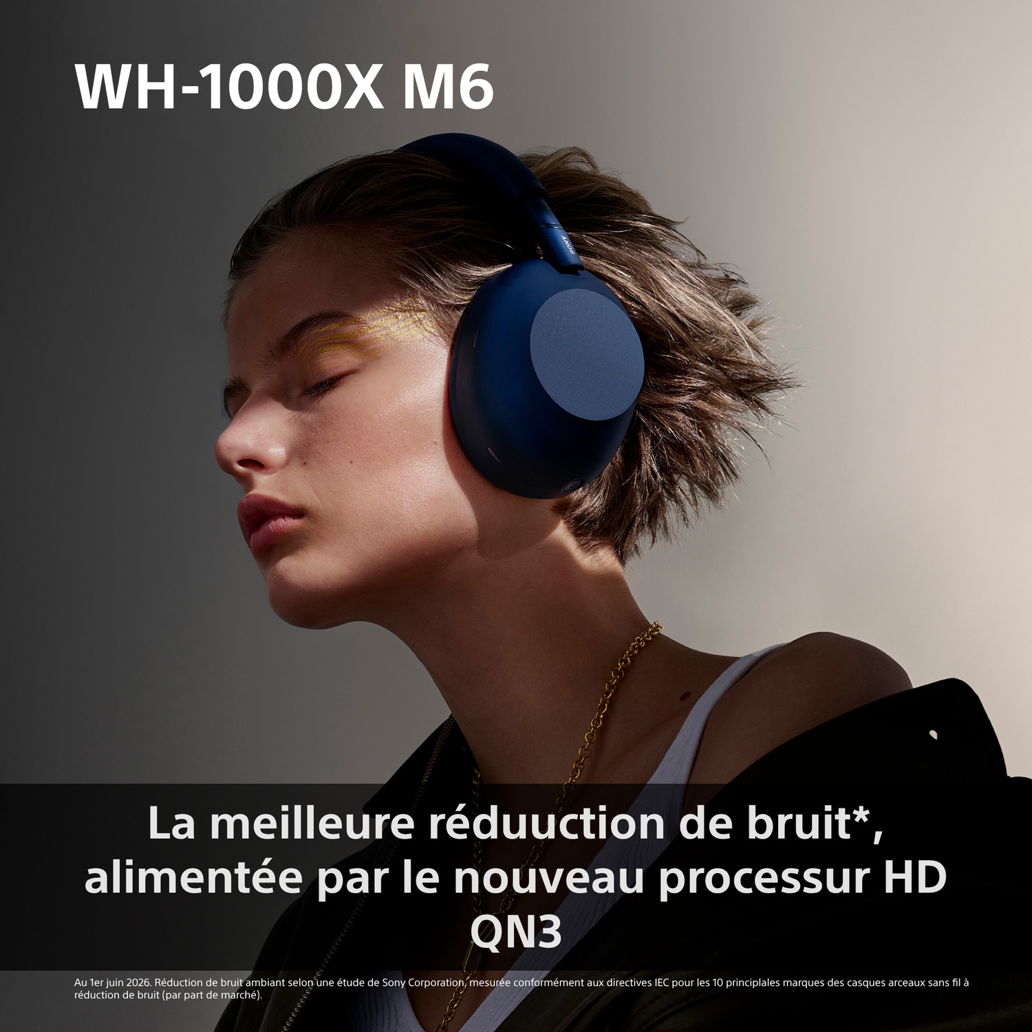 Une femme aux cheveux courts porte un casque bleu WH-1000X M6 les yeux fermés.
