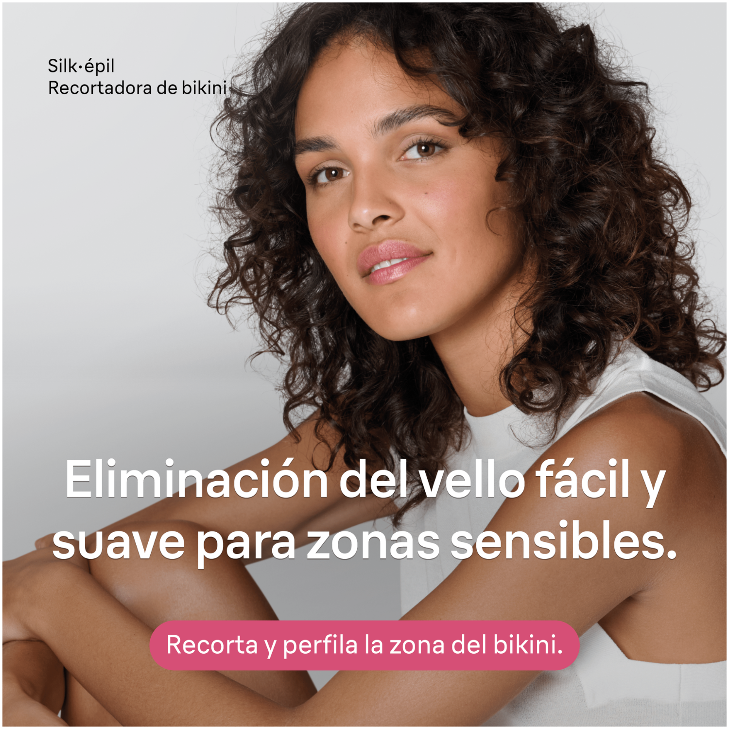 Una mujer con cabello rizado oscuro y top blanco posa para un anuncio de producto.