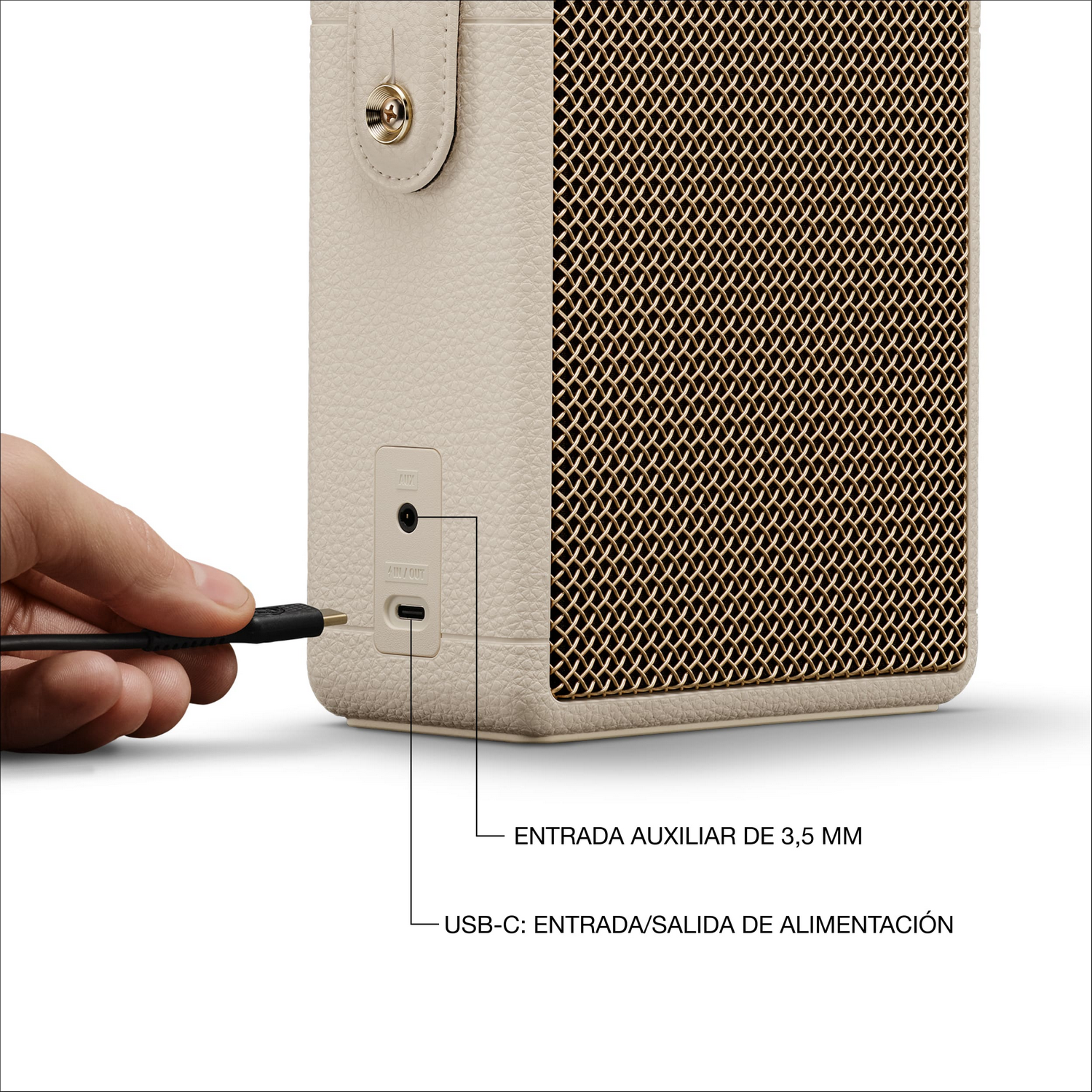 Un cable USB-C se conecta a un altavoz beige, mostrando etiquetas de puertos AUX y USB-C.