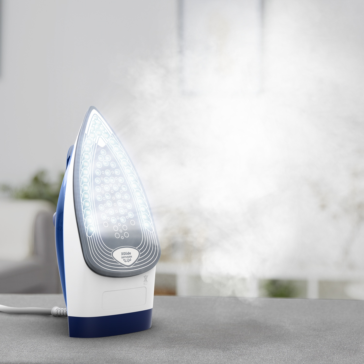 A white and blue steam iron stands upright on a grey surface, emitting a cloud of steam from its soleplate.