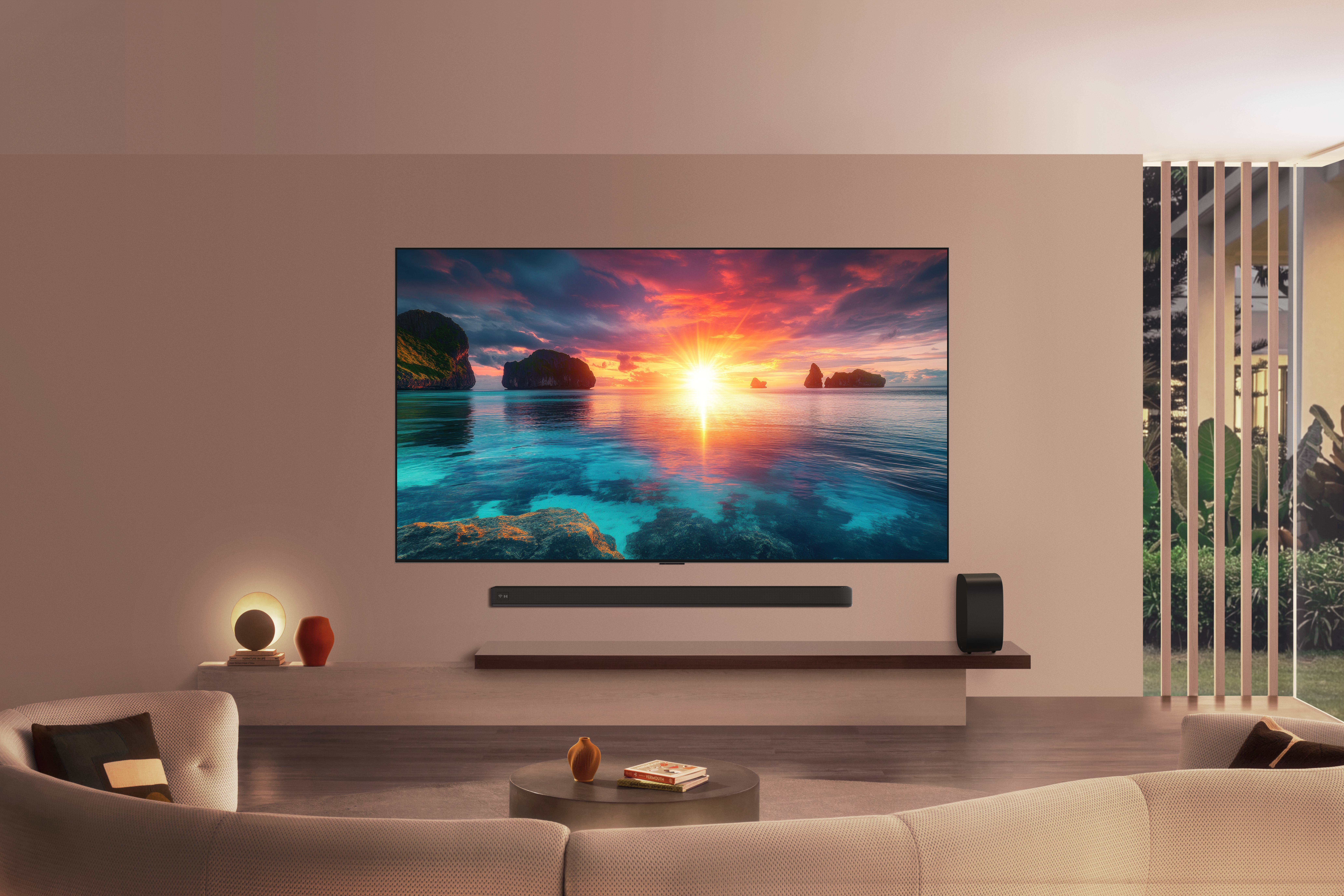 Nappali egy nagy TV-vel a falon, amely naplementét mutat, hangsávval és ülőhelyekkel.