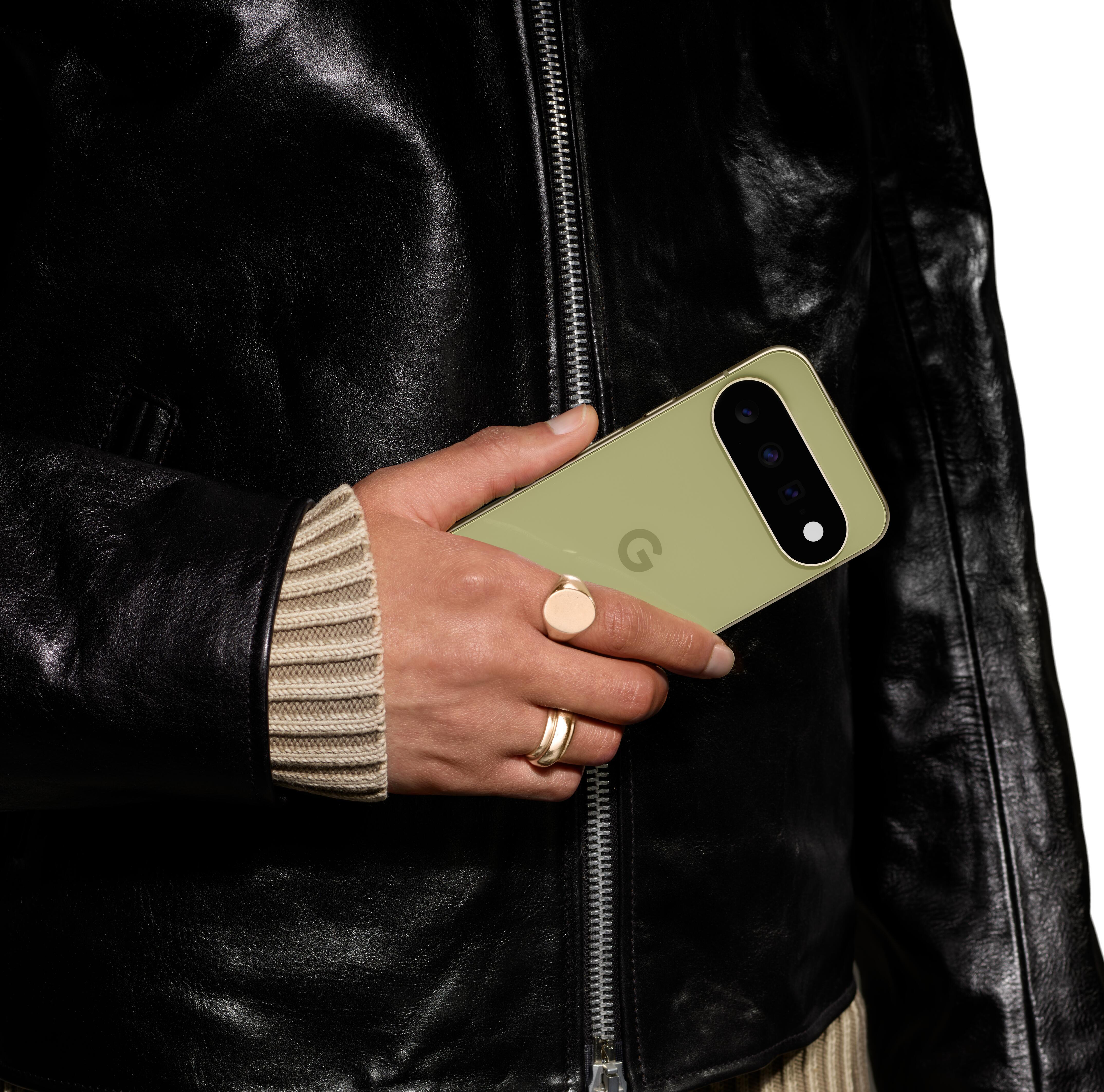 Person im schwarzen Lederjackett hält ein hellgrünes Smartphone in der Hand.