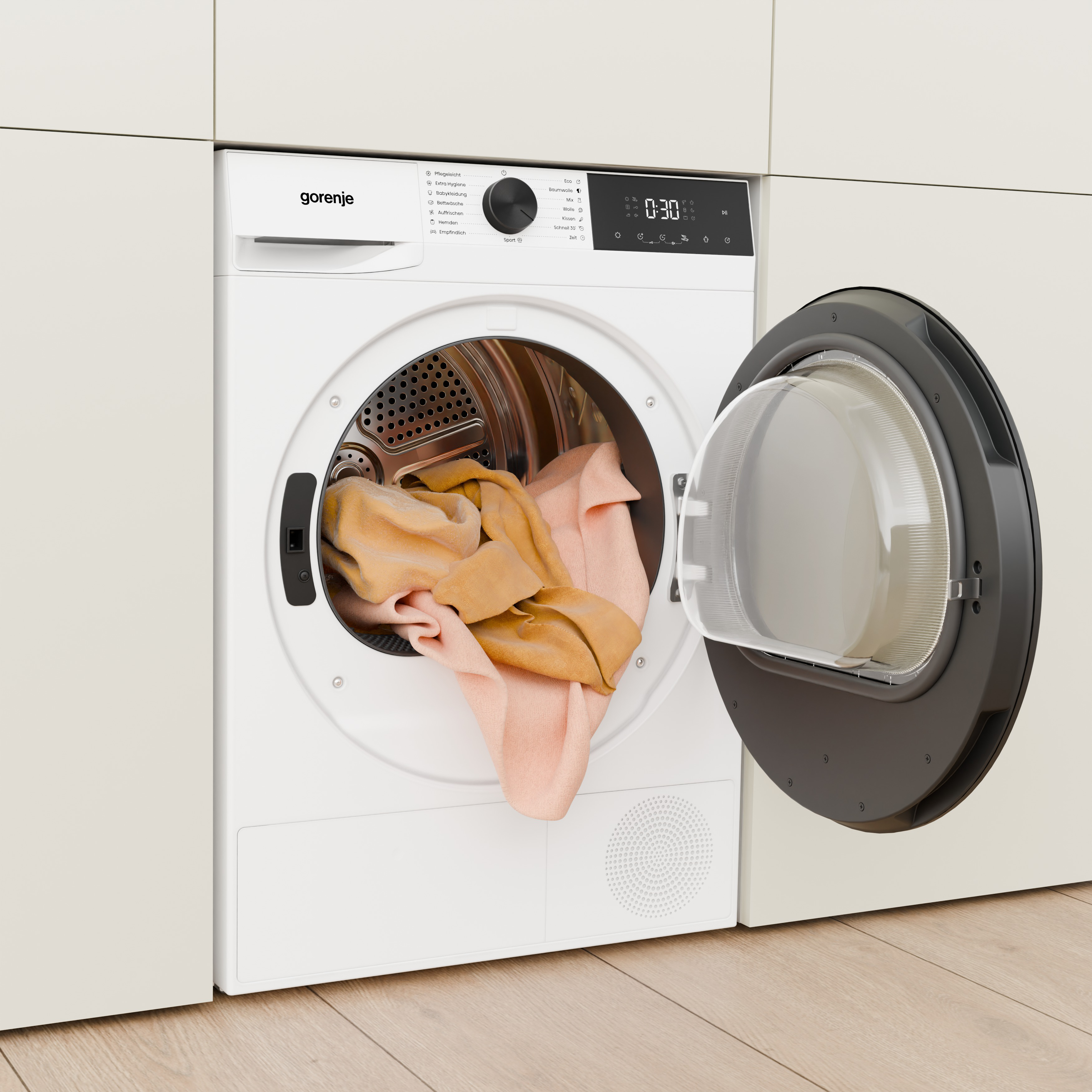 Egy nyitott ajtajú, fehér Gorenje szárítógép sárga és rózsaszín ruhákkal van tele.