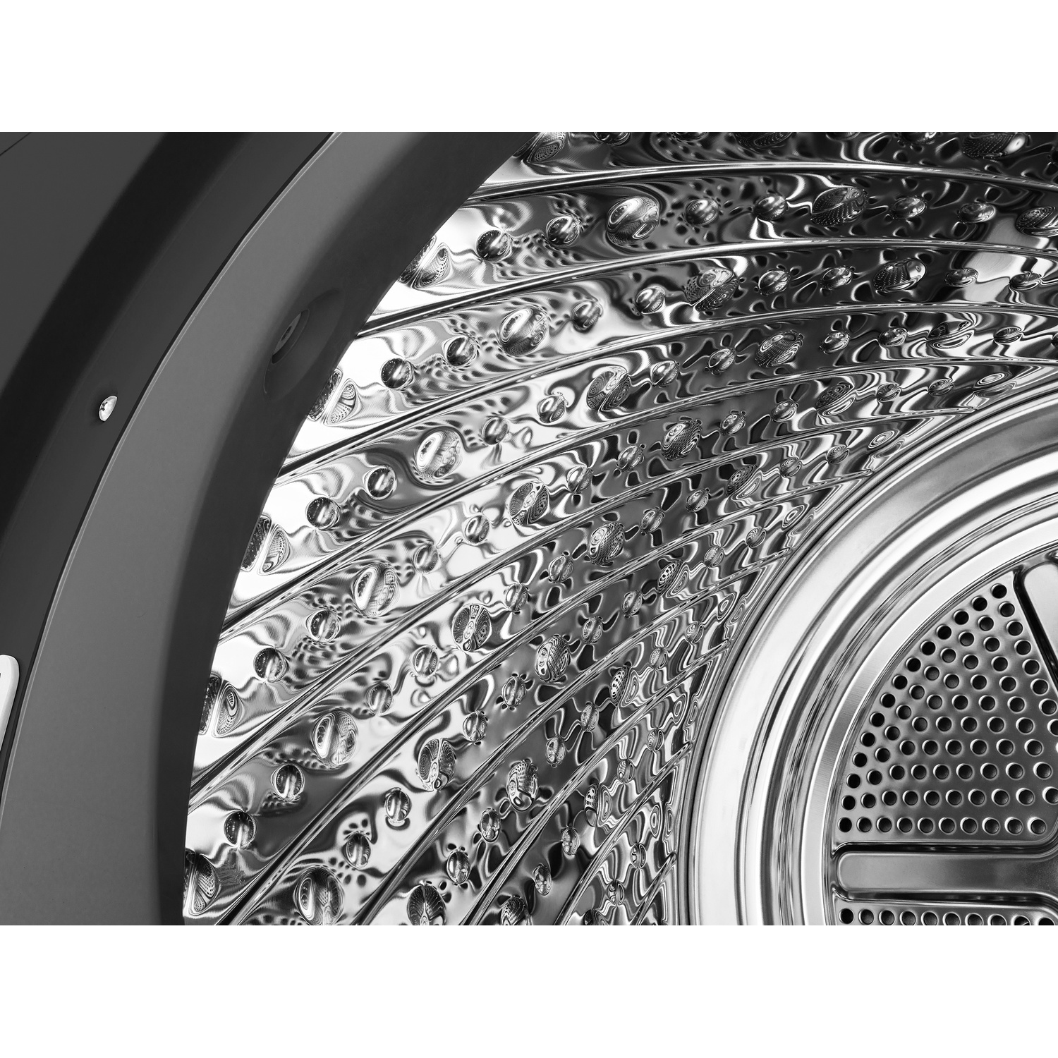 Close-up of the shiny, textured drum of a modern clothes dryer.