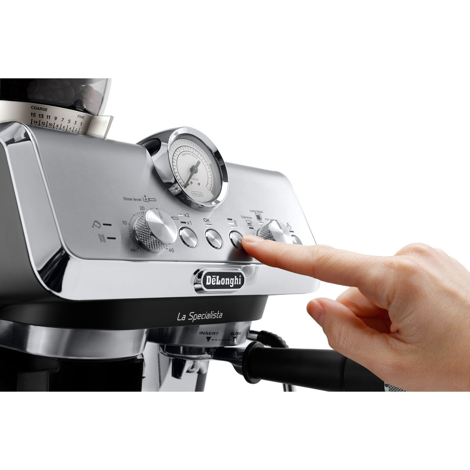 Une main appuie sur un bouton de la machine à expresso argentée DeLonghi La Specialista.