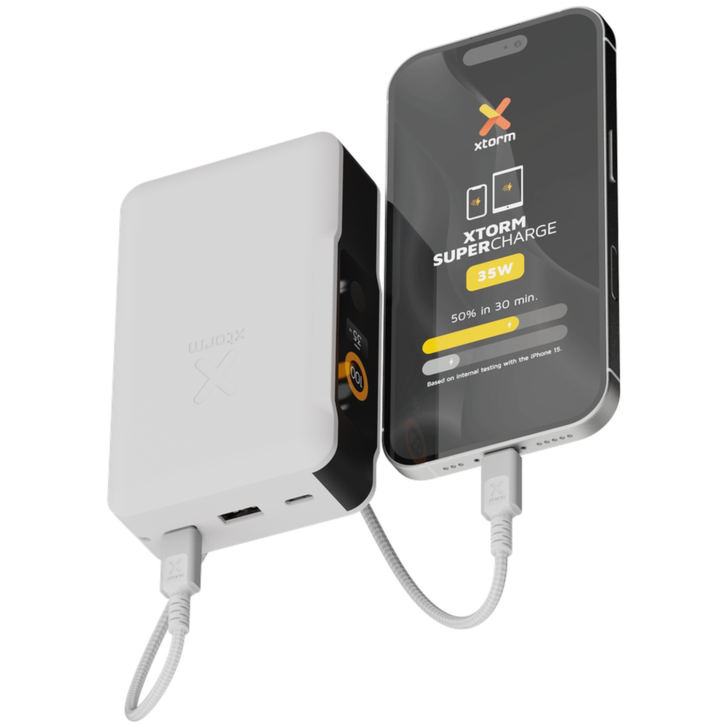 Une batterie externe blanche Xtorm Supercharge charge un smartphone avec un câble blanc sur fond neutre.