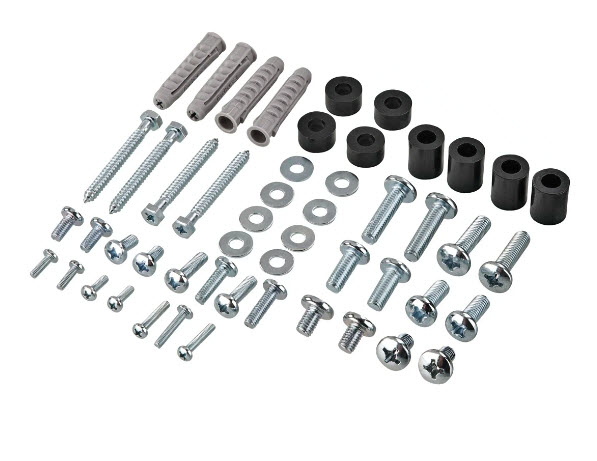 Verschiedene silberne Schrauben, Metallscheiben, schwarze Zylinder und graue Dübel auf weißem Grund.