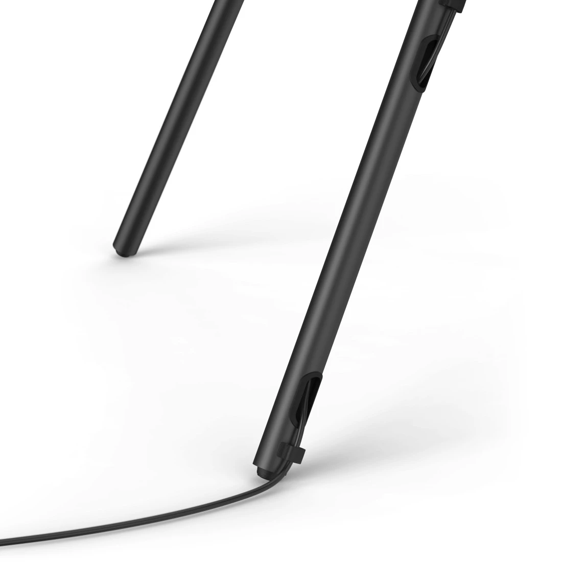 Zwei schwarze Stuhlbeine auf weißem Hintergrund, ein Kabel verläuft durch ein Loch im vorderen Bein.