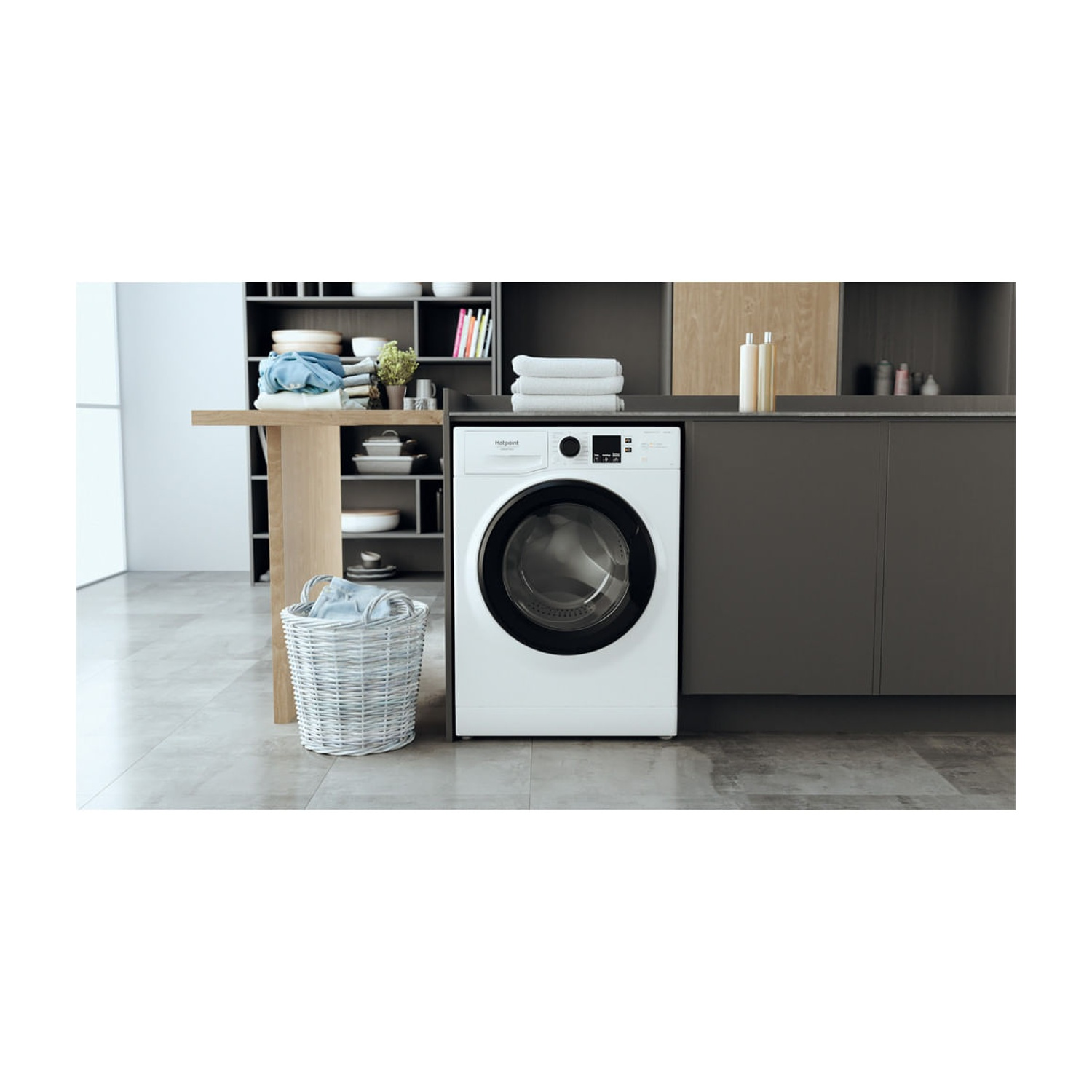 Una lavatrice bianca si trova in una cucina moderna accanto a un cesto della biancheria bianco.