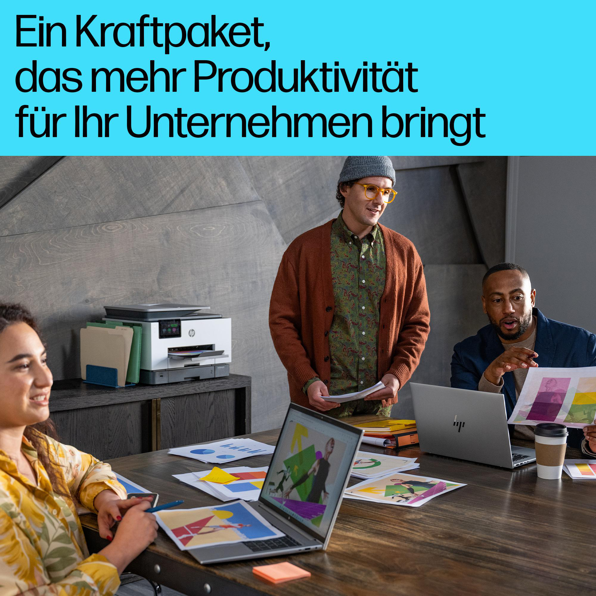 Drei Kollegen arbeiten in einem modernen Büro an Laptops und Dokumenten zusammen.