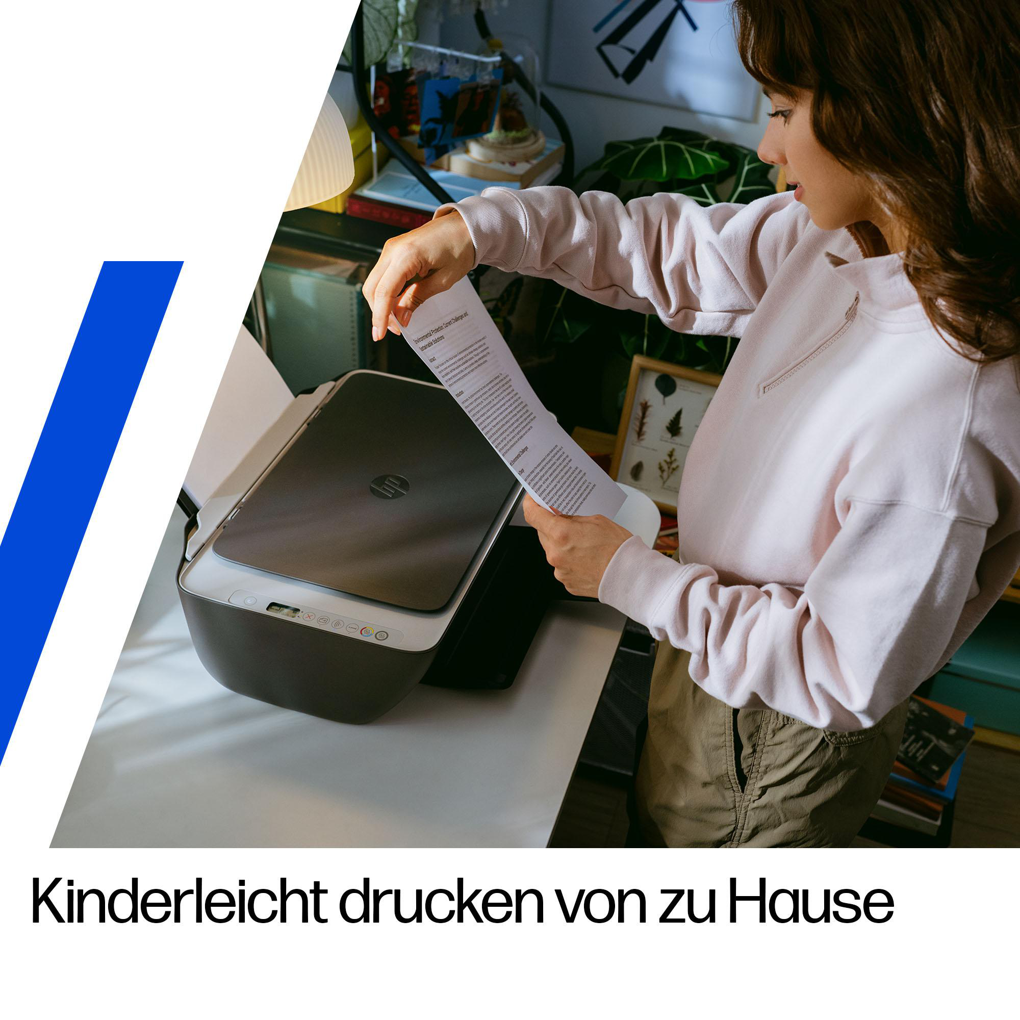 Eine Frau in einem rosafarbenen Pullover nimmt gedrucktes Papier aus einem Drucker in einem Zimmer.