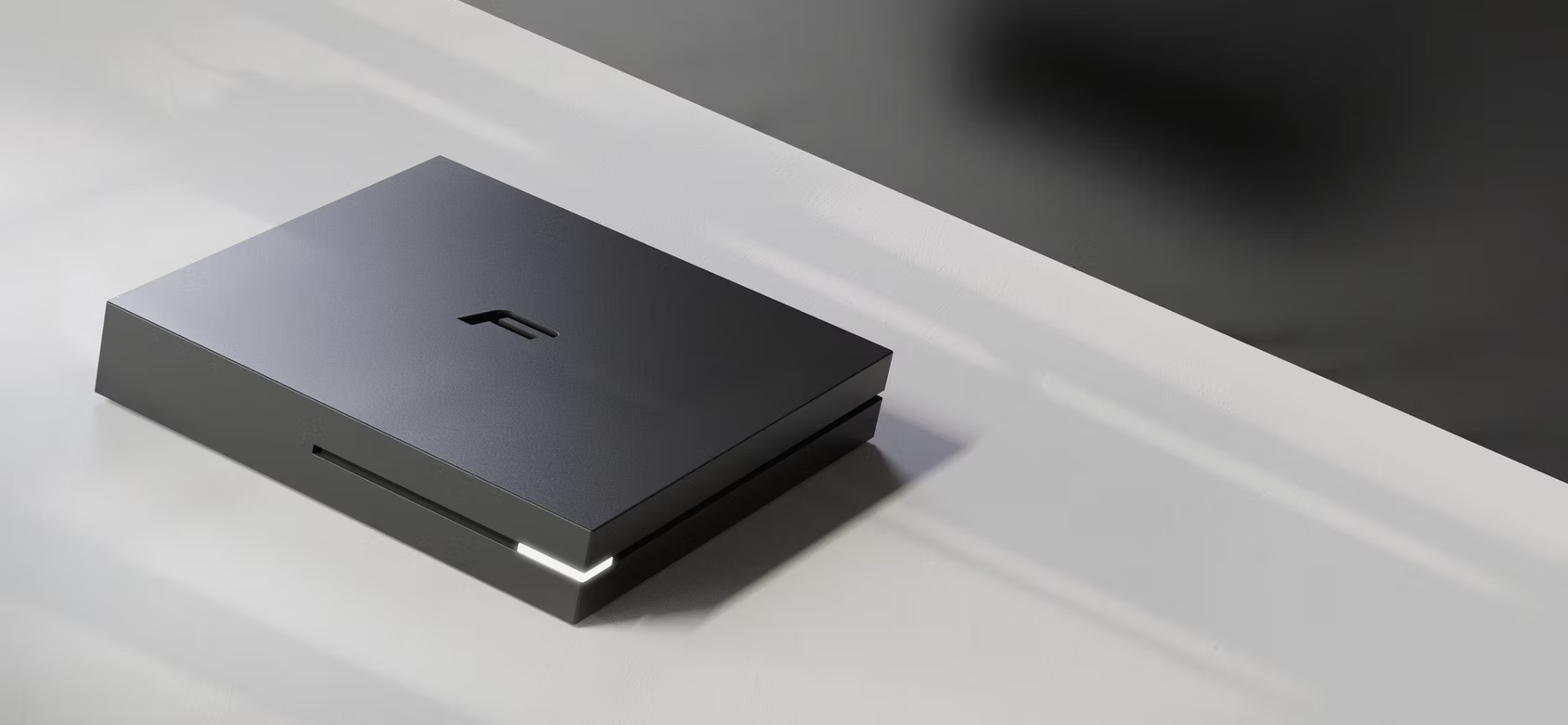 Un elegante dispositivo elettronico nero con luce LED bianca su una superficie bianca.
