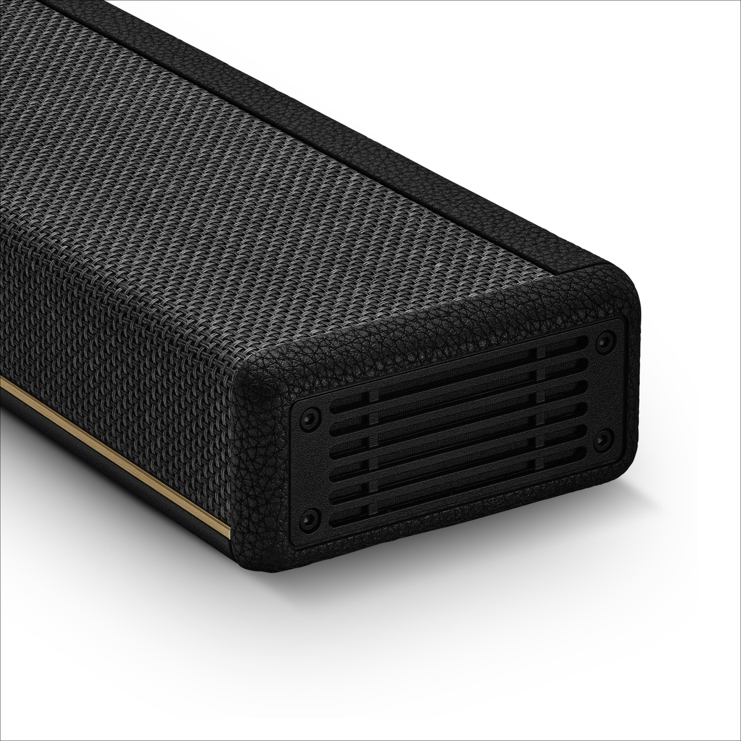 Une barre de son noire avec une grille en tissu, des bordures en cuir et un accent doré sur fond blanc.