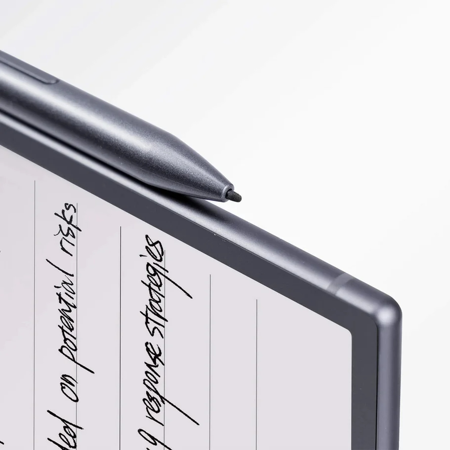 A grey stylus rests on top of a digital tablet showing handwritten notes on lined paper against a white background.