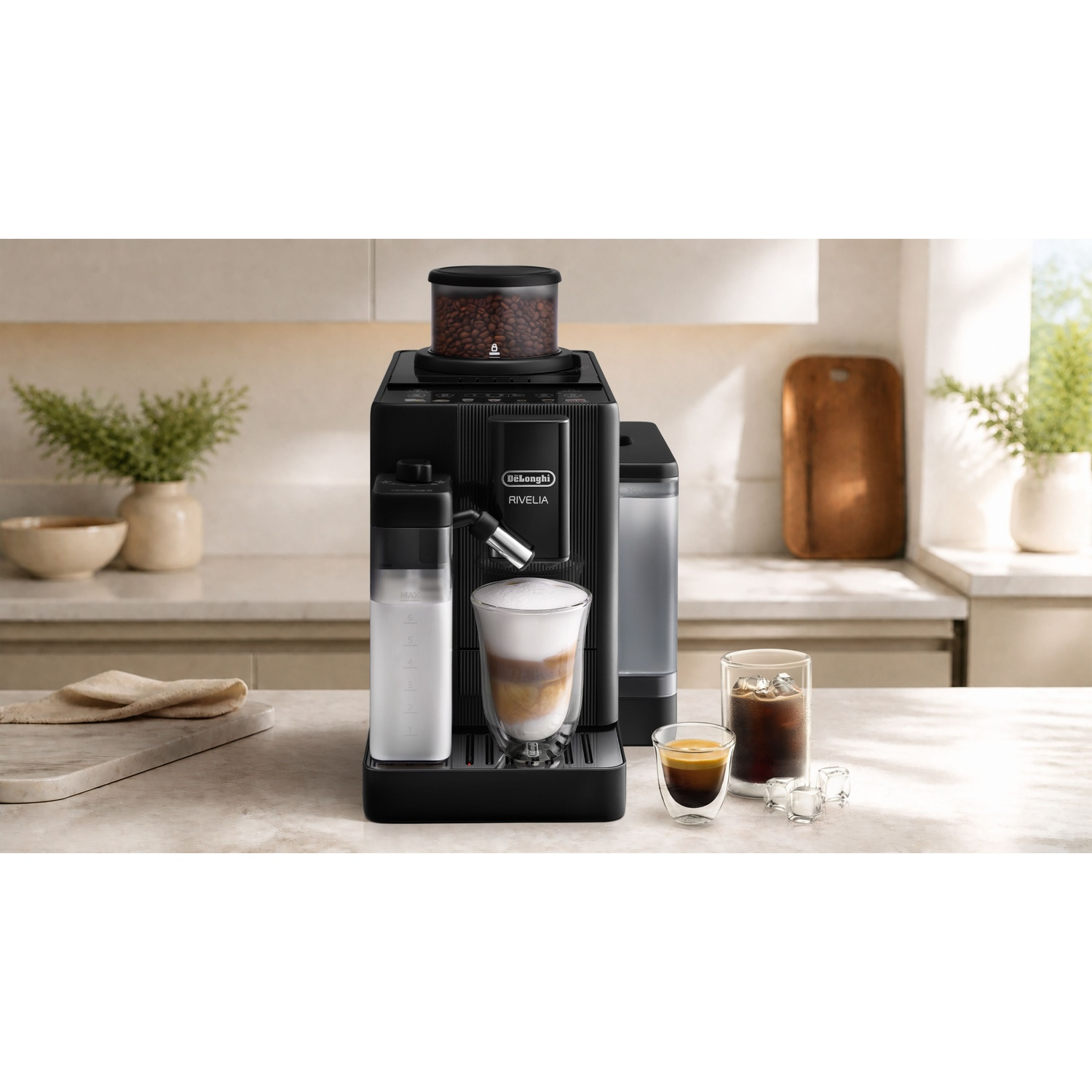 Cafetière noire DeLonghi Rivelia sur un comptoir de cuisine avec des boissons et des plantes à l'arrière-plan.
